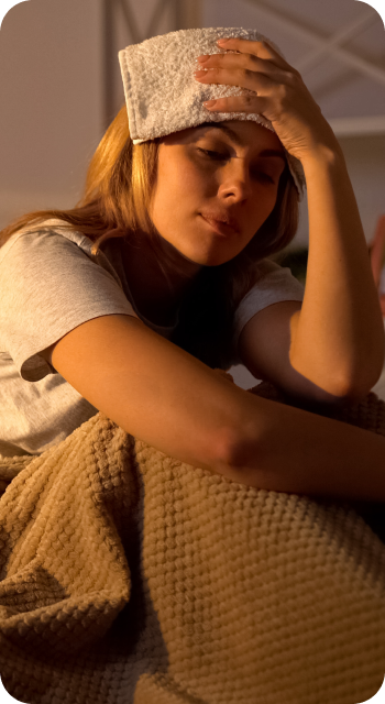 Woman holding a flannel to her head in low light
